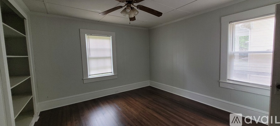 A room with a window and a fan on the ceiling.