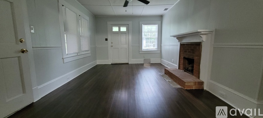A room with a fireplace and a door on the left.