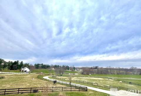 A farm with a fence and animals in the foreground.