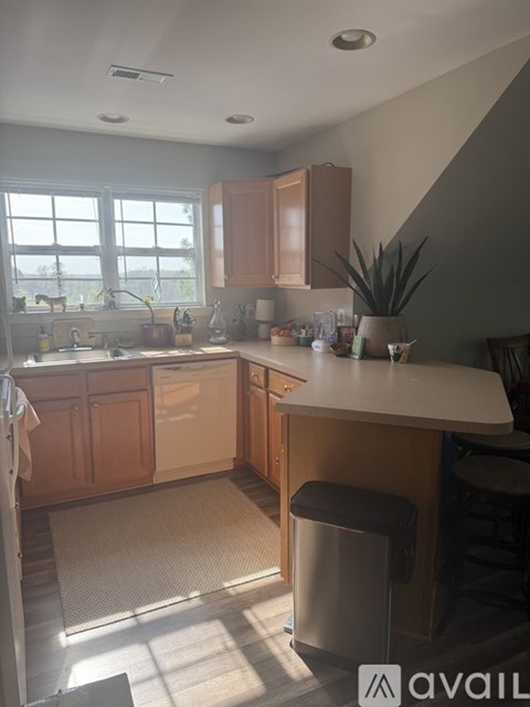 A kitchen with wooden cabinets and a large window.