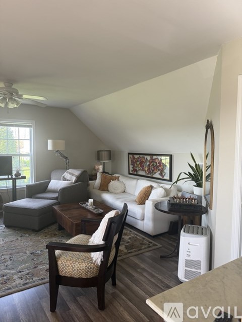 A living room with a white couch and a wooden coffee table.