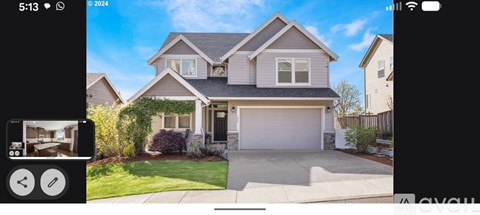 A house with a grey roof and a white garage door.
