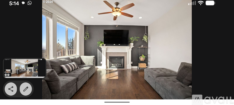 A modern living room with a grey sofa and a fireplace.