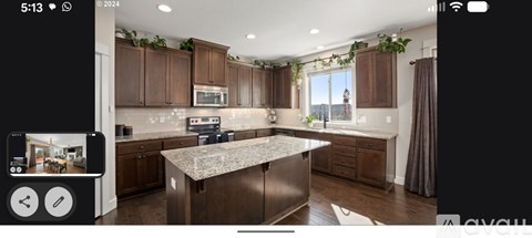 A modern kitchen with dark wood cabinets and a central island.