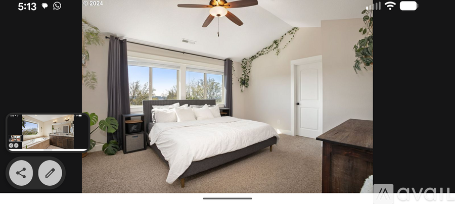 A bedroom with a large bed and a ceiling fan.