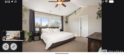 A bedroom with a large bed and a ceiling fan.