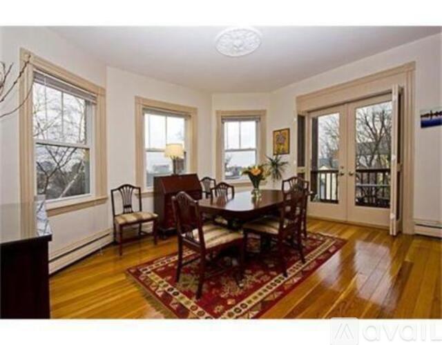 A dining room with a table and chairs.