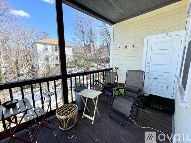 A balcony with a table and chairs overlooking a river.