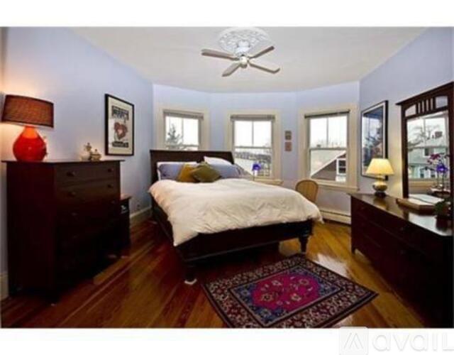 A bedroom with a bed, dresser, and window.