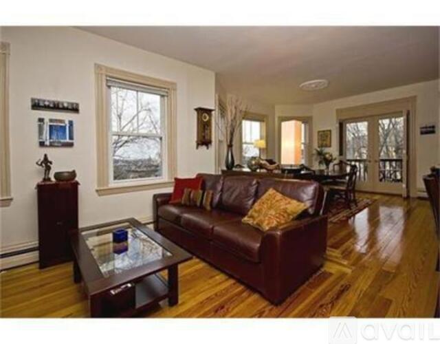 A living room with a brown leather couch and a glass coffee table.