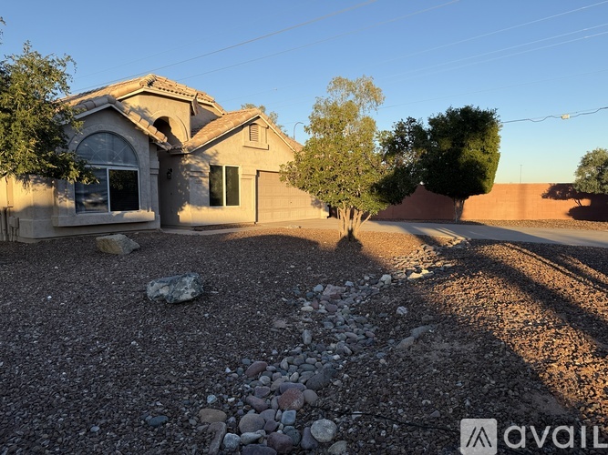 A house with a gravel driveway and a tree in front.