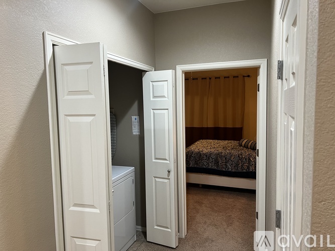 A bedroom with a bed, a wardrobe, and a small fridge.