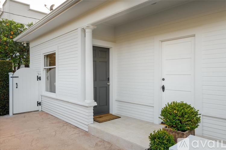 A white house with a grey door and a small window.