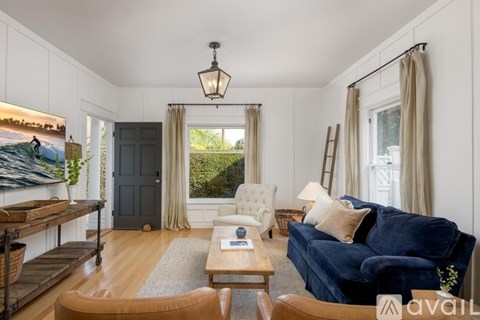 A living room with a blue couch and a wooden coffee table.