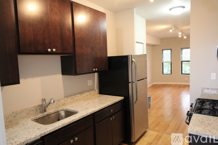 A kitchen with dark wood cabinets and a stainless steel refrigerator.