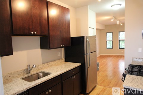 A kitchen with dark wood cabinets and a stainless steel refrigerator.