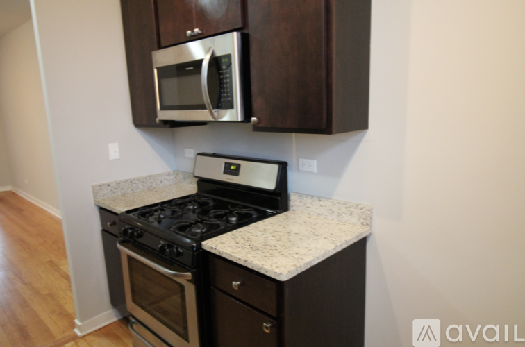 A kitchen with a black stove top oven and microwave above it.