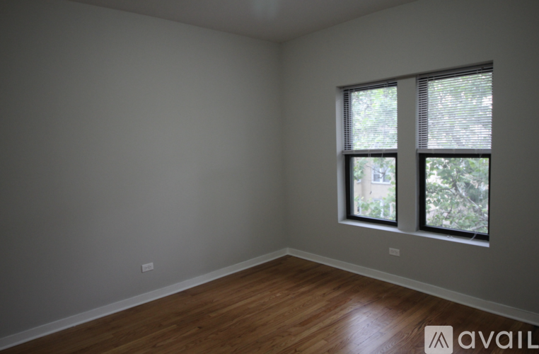 A room with wooden floors and two windows.