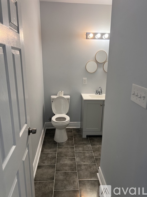 A bathroom with a toilet, sink, and a mirror.