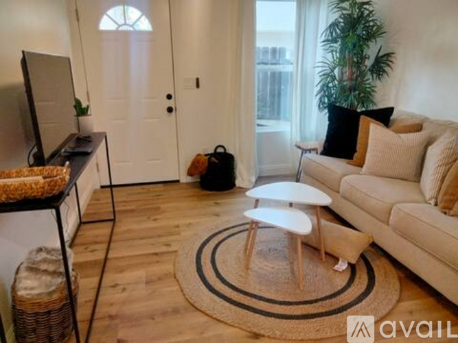 A living room with a white couch, a white coffee table, and a white door.