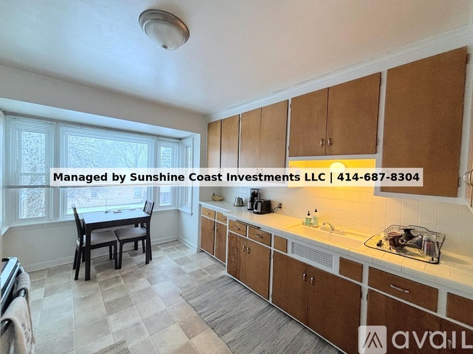 A kitchen with wooden cabinets and a checkered floor.