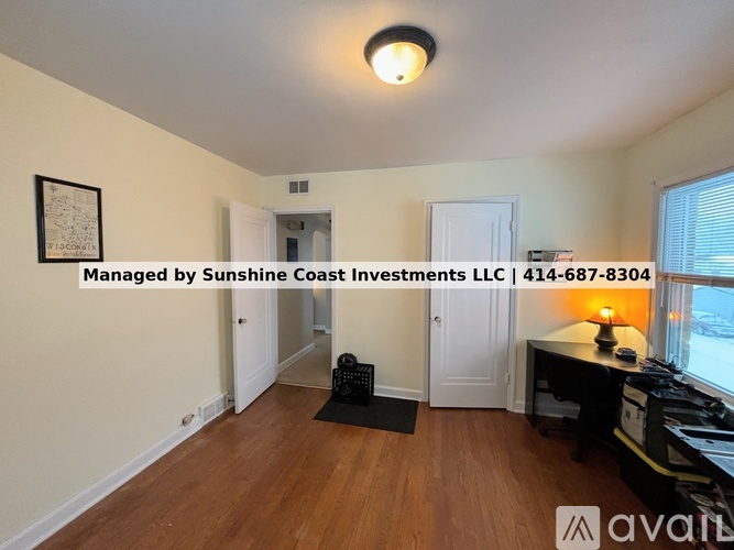 A room with wooden floors and a white ceiling with a light fixture.