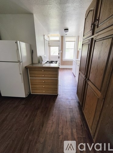 A kitchen with a white refrigerator and wooden cabinets.