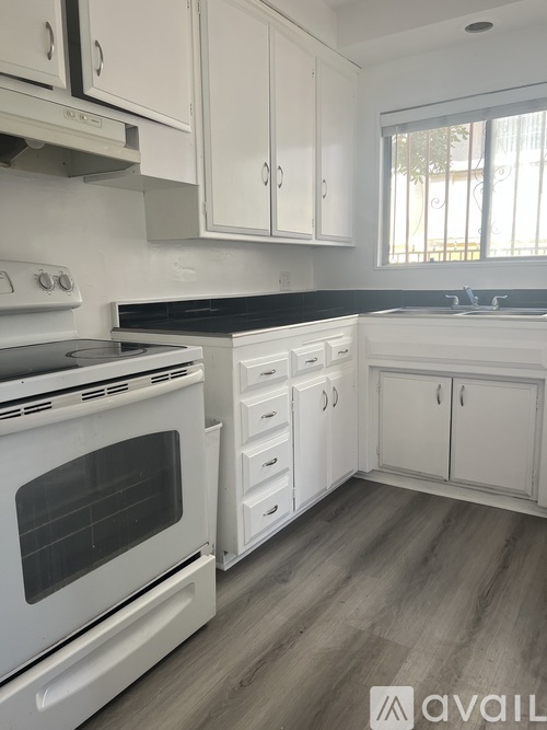 A kitchen with white appliances and cabinets.