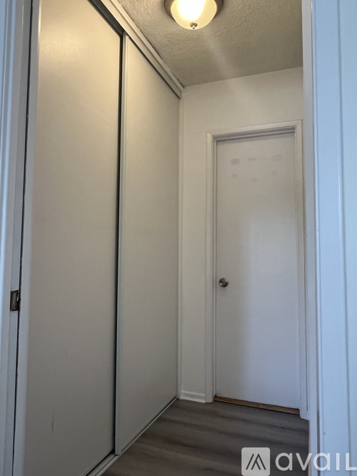 A hallway with a door on the right and a wall on the left.
