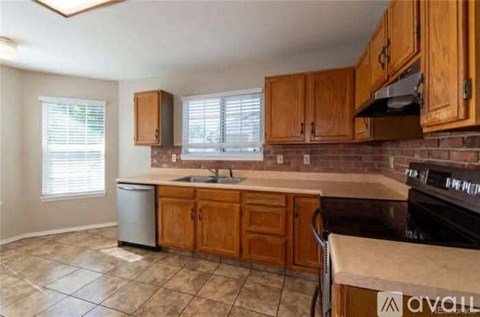 A kitchen with wooden cabinets and a black stove top oven.