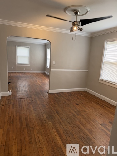 A room with wooden floors and a ceiling fan.