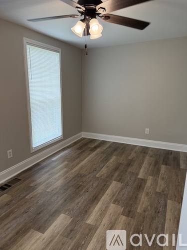 A room with wooden flooring and a ceiling fan.