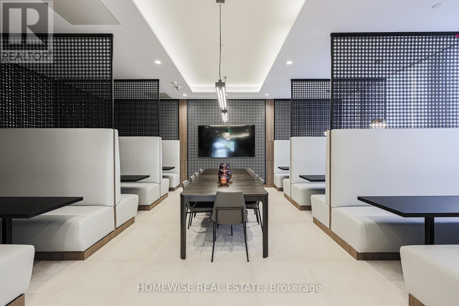 A modern dining room with a long table and chairs.