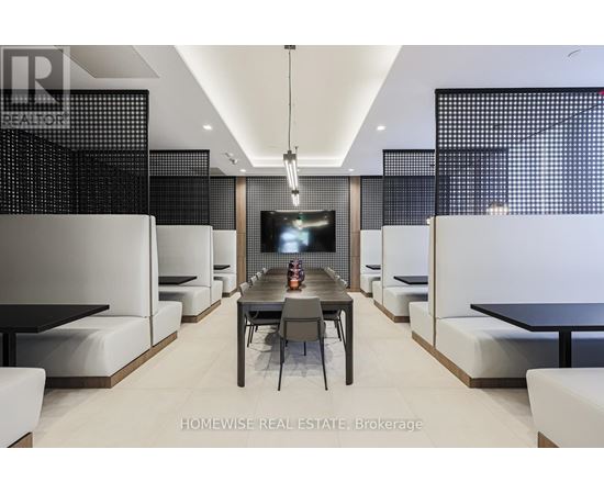 A modern dining room with a long table and chairs.