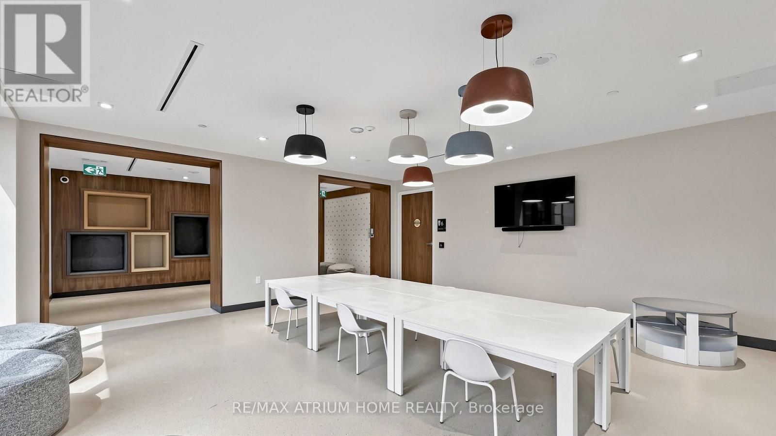A modern dining room with a long white table and chairs.