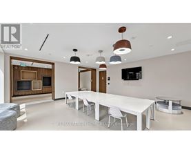 A modern dining room with a long white table and chairs.