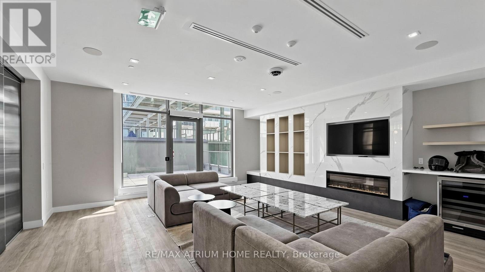 A modern living room with a glass table and a grey sofa.