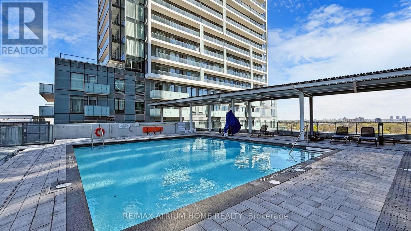 A swimming pool on a rooftop patio with a person in the pool.
