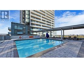A swimming pool on a rooftop patio with a person in the pool.
