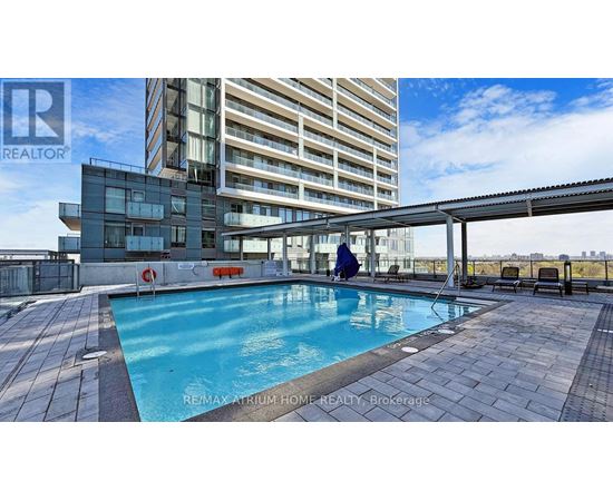 A swimming pool on a rooftop patio with a person in the pool.