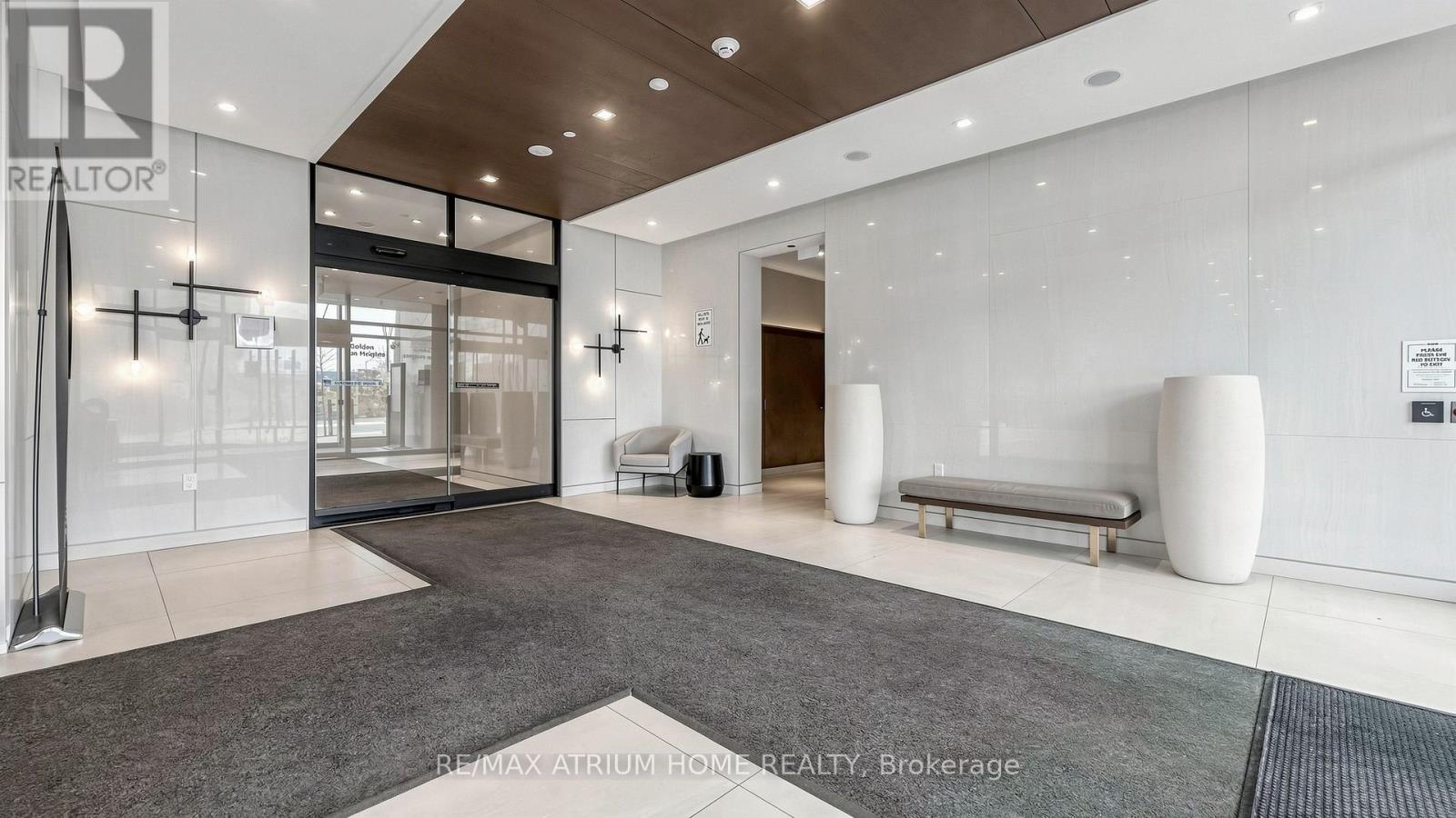 A spacious lobby area with a glass wall and a bench.