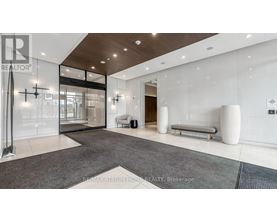 A spacious lobby area with a glass wall and a bench.