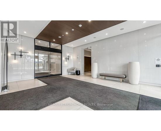 A spacious lobby area with a glass wall and a bench.