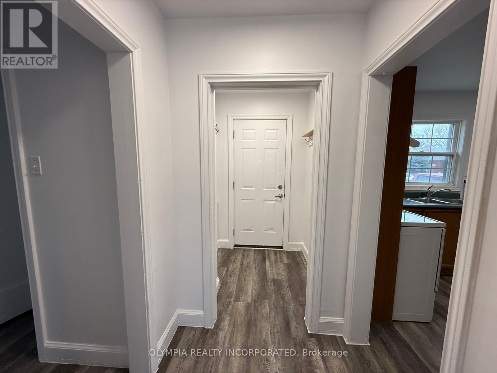 A white door is in the middle of a hallway.