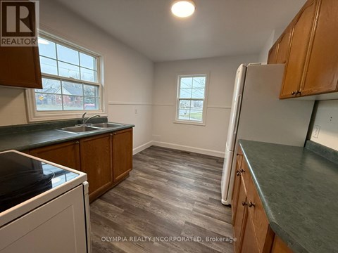 A kitchen with wooden cabinets and a window.