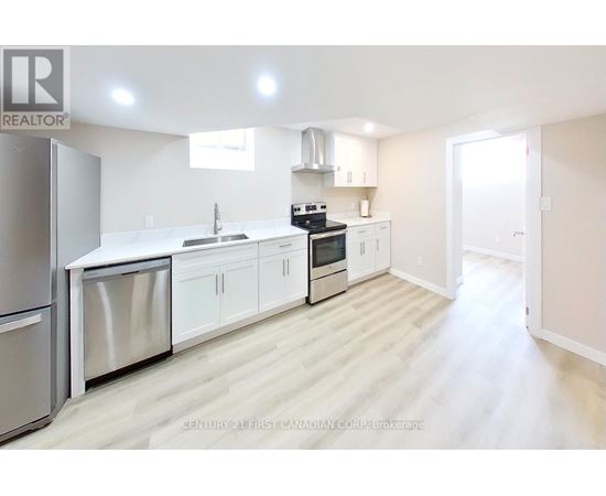 A modern kitchen with white cabinets and stainless steel appliances.