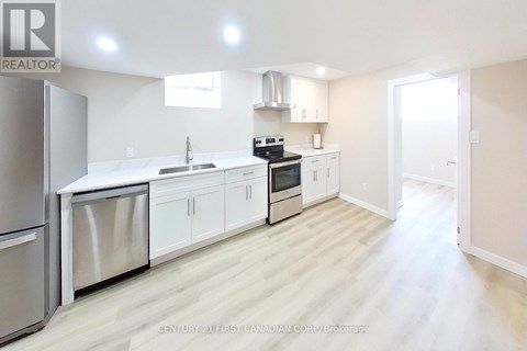A modern kitchen with white cabinets and stainless steel appliances.
