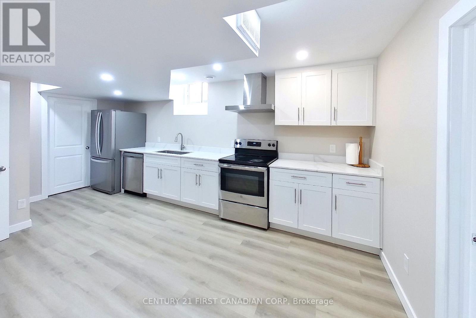 A clean, modern kitchen with white cabinets and stainless steel appliances.