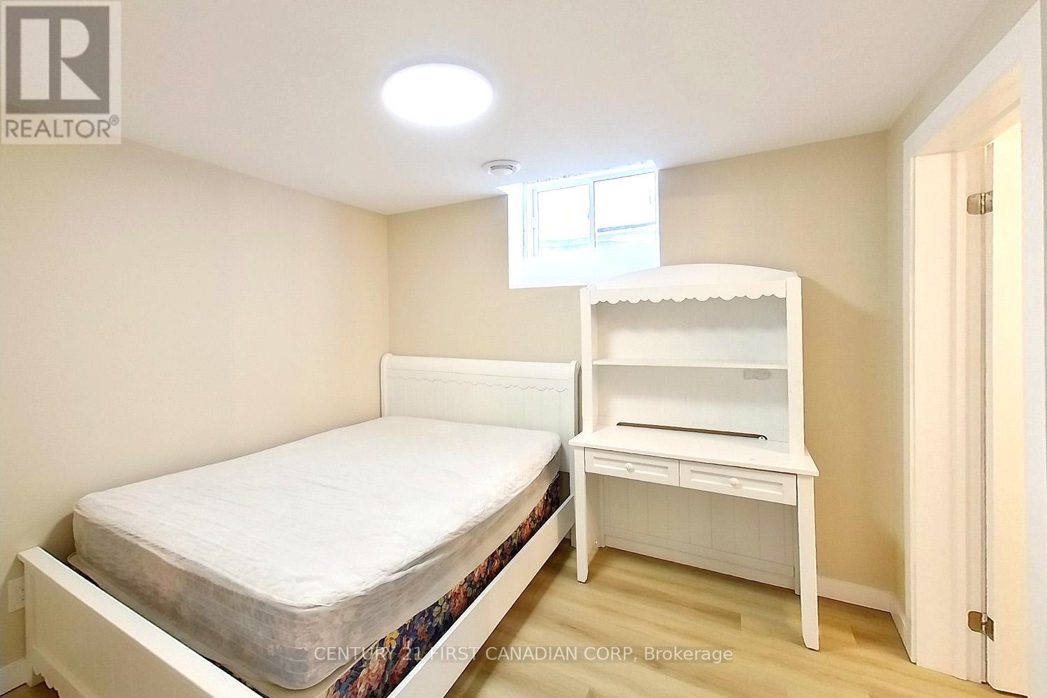 A bedroom with a bed and a desk.