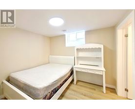A bedroom with a bed and a desk.